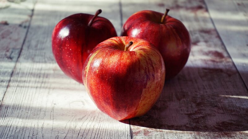 Fresh red apples on a rustic wooden table